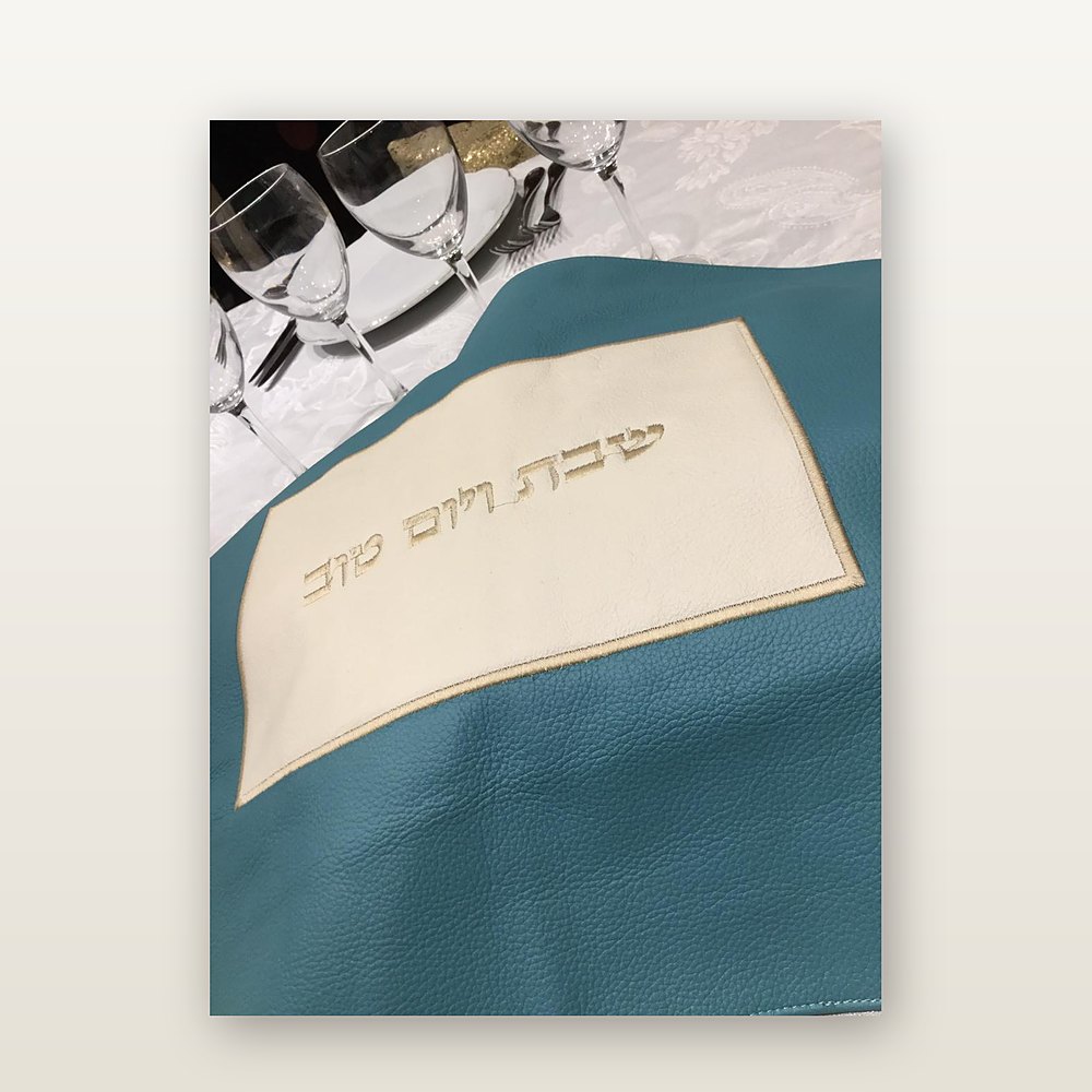 כיסוי חלה מעור בטורקיז עם פס שמנת ורקמת זהב של שבת ויום טוב, על שולחן ערוך