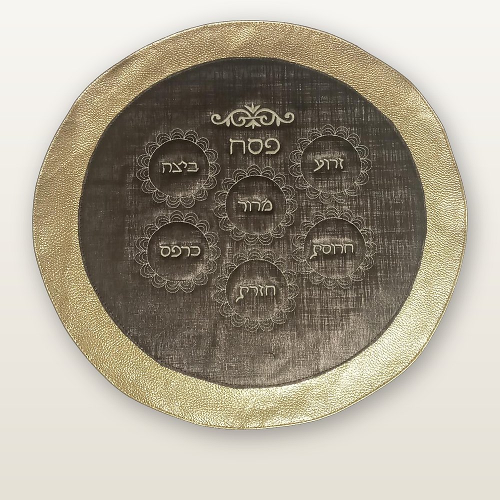 כיסוי מצה עגול, שוליים בגוון זהב סביב מרכז חום כהה עם רקמת סימני הסדר בחוט שמנת