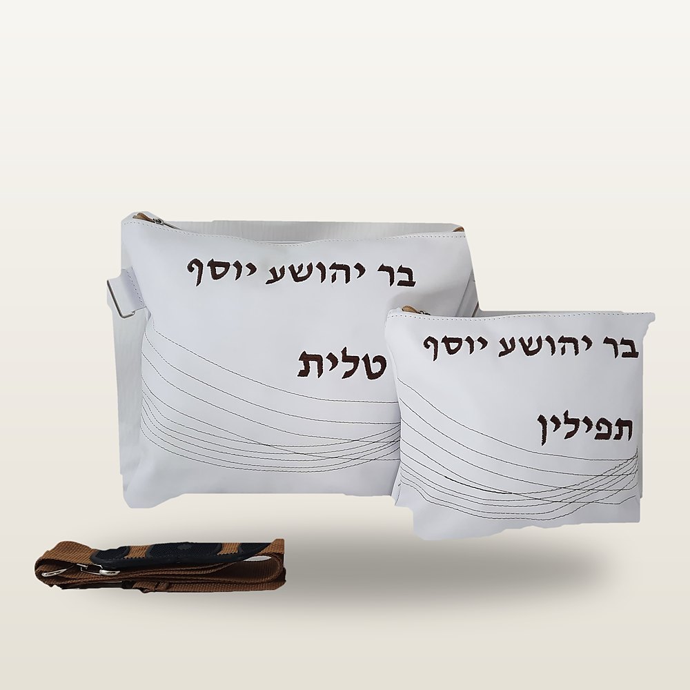 תיק טלית ונרתיק תפילין מעור לבן עם רקמה עברית בחום כהה, תפרים מעוגלים עדינים ורצועה חומה